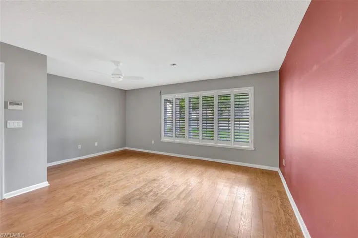 Spare room with wood finished floors, ceiling fan, and a textured ceiling