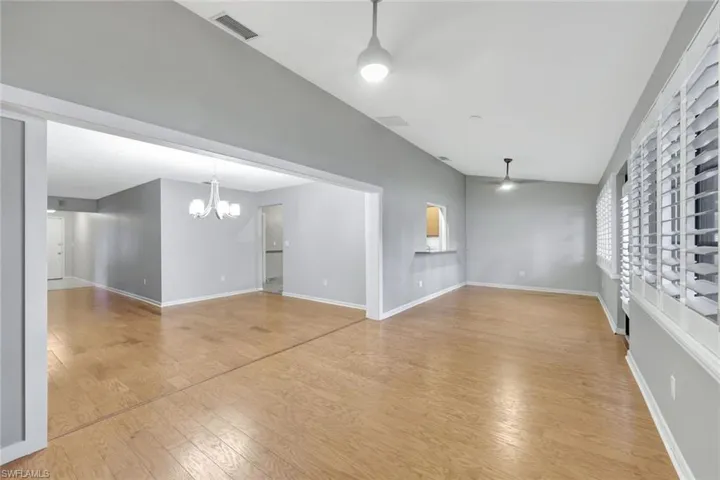Unfurnished living room featuring a chandelier and light wood-type flooring