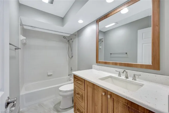 Bathroom with vanity, shower / tub combination, and recessed lighting