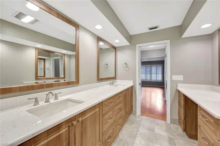 Full bathroom with double vanity and recessed lighting