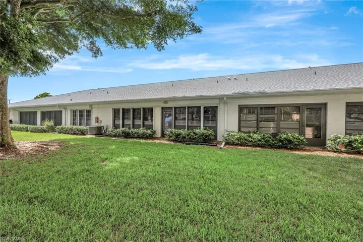 Back of property featuring a yard and stucco siding
