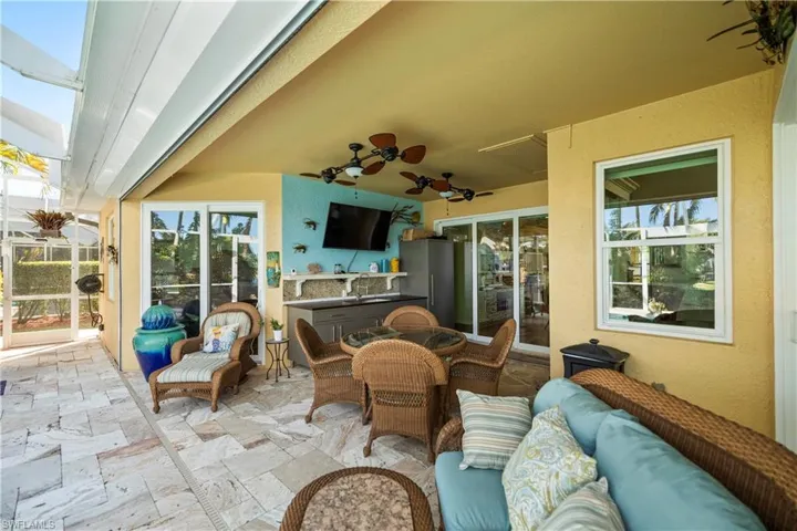 View of patio featuring an outdoor hangout area, ceiling fan, a grill, and a sunroom