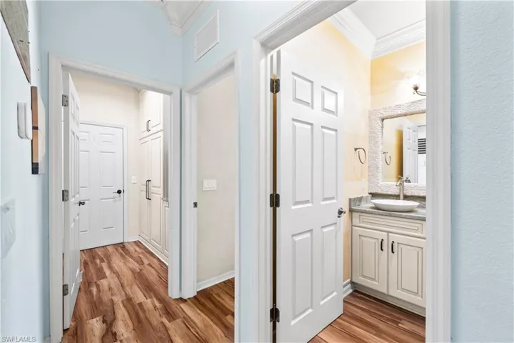 Corridor featuring ornamental molding and light wood-style flooring