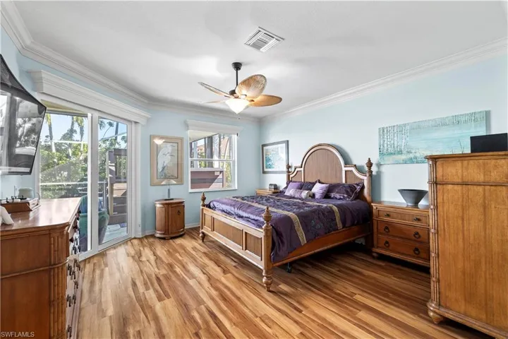 Bedroom featuring access to outside, ornamental molding, wood finished floors, and a ceiling fan