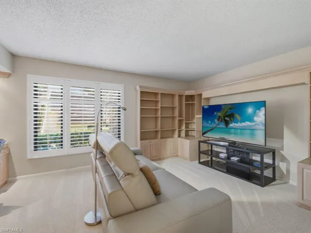 Living area featuring a textured ceiling and light carpet