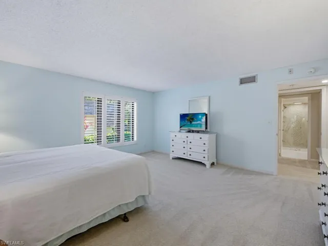 Bedroom featuring light carpet and a textured ceiling