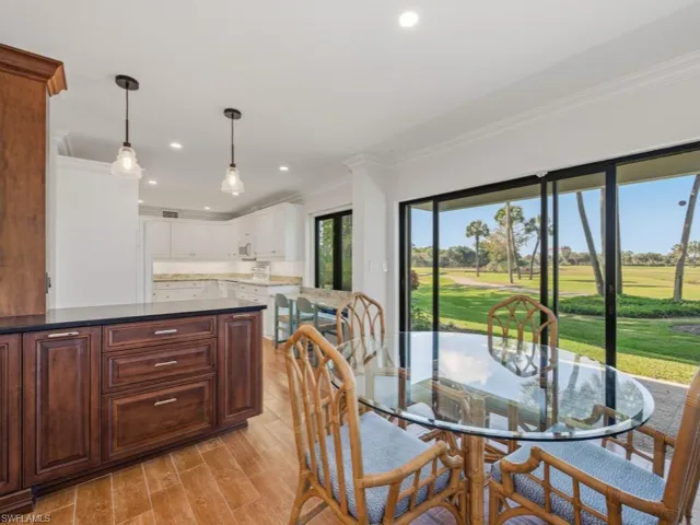 Dining space featuring ornamental molding, recessed lighting, wood finish floors, and view of golf course