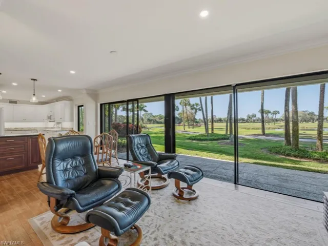Living room featuring recessed lighting, golf course view, light wood-style floors, and crown molding