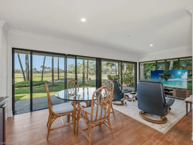 Dining room with wood finished floors, crown molding, recessed lighting, and view of golf course