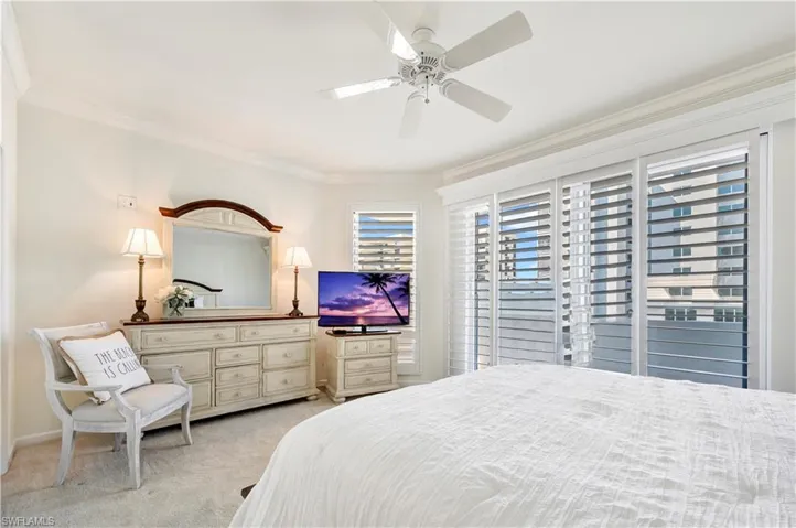 Bedroom featuring ceiling fan, access to exterior, light carpet, and ornamental molding