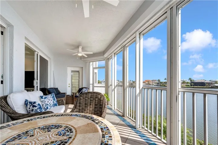 Sunroom / solarium with a water view and ceiling fan