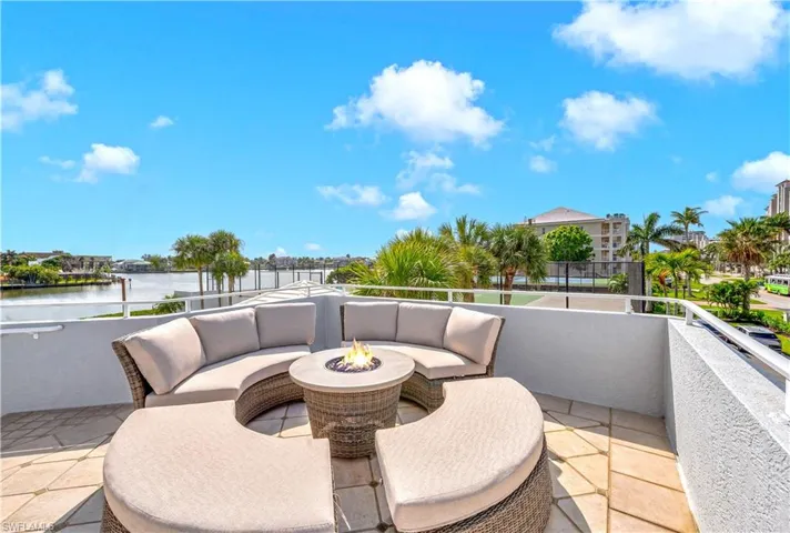 View of patio / terrace featuring a balcony, a water view, and an outdoor living space with a fire pit