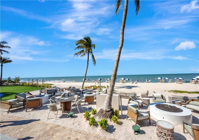 View of water feature with a fire pit and a beach view