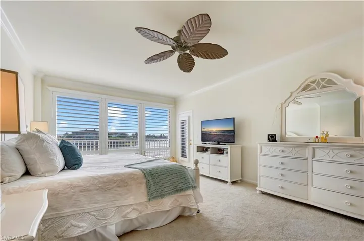 Bedroom featuring ceiling fan, light colored carpet, access to exterior, and crown molding
