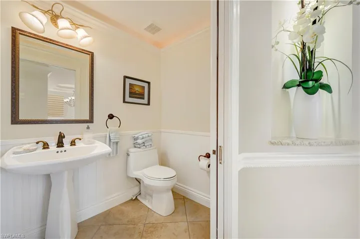 Bathroom with tile patterned flooring, toilet, and crown molding