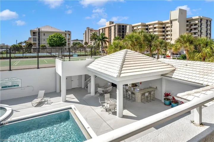 View of pool featuring tennis court