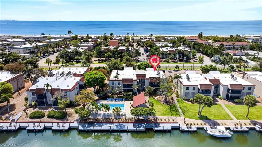 Waterfront condominium complex featuring a dock, swimming pool, and proximity to the Gulf of Mexico