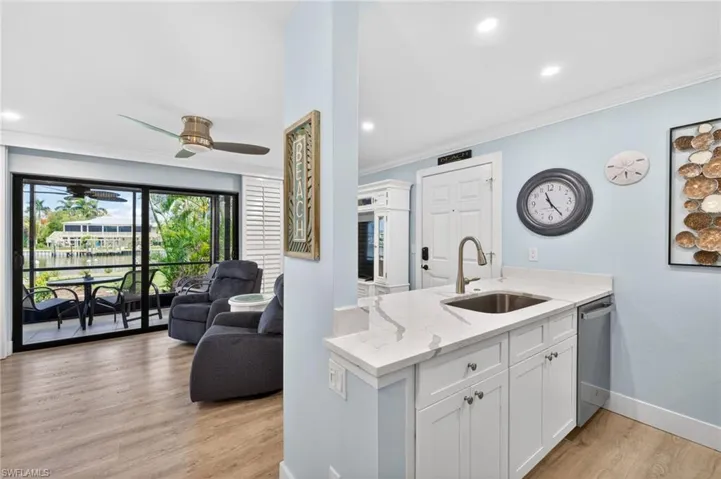 Kitchen featuring white cabinetry, a stainless steel sink, and a light-toned countertop