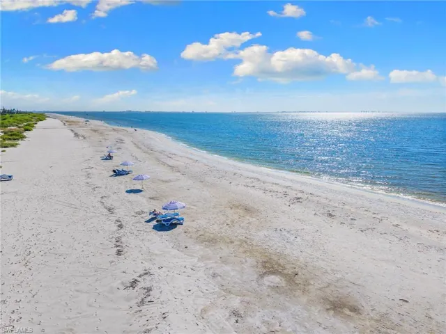 Expansive sandy beach bordering a sparkling blue ocean under a clear sky