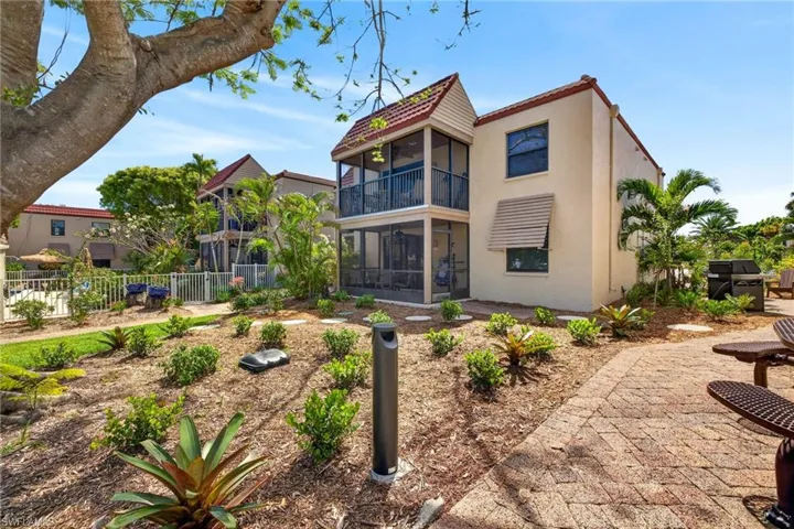 First floor stucco property featuring a red tile roof and dual-level screened balconies