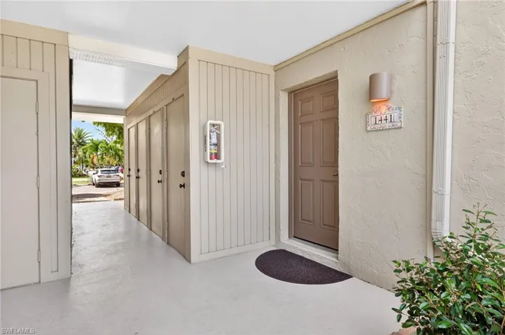 Covered entryway featuring a paneled door, stucco exterior, and a wall-mounted light fixture
