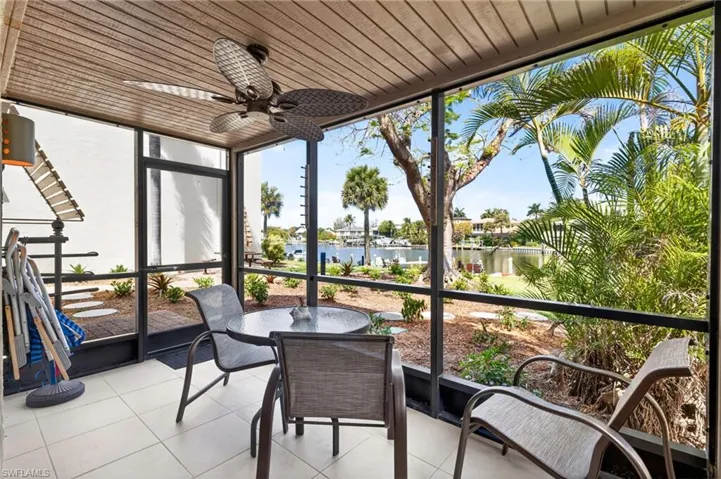 Screened outdoor patio featuring tile flooring, a wood-finish ceiling, and an overhead ceiling fan