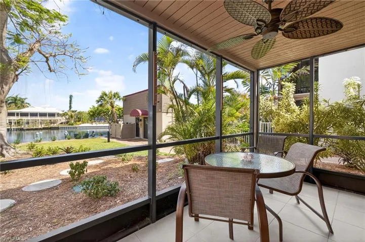 Screened patio featuring a ceiling fan with integrated lighting, wood-finish ceiling, and tile flooring