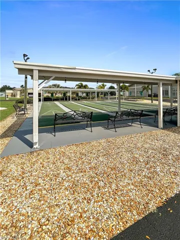 View of community with shuffleboard and a patio area