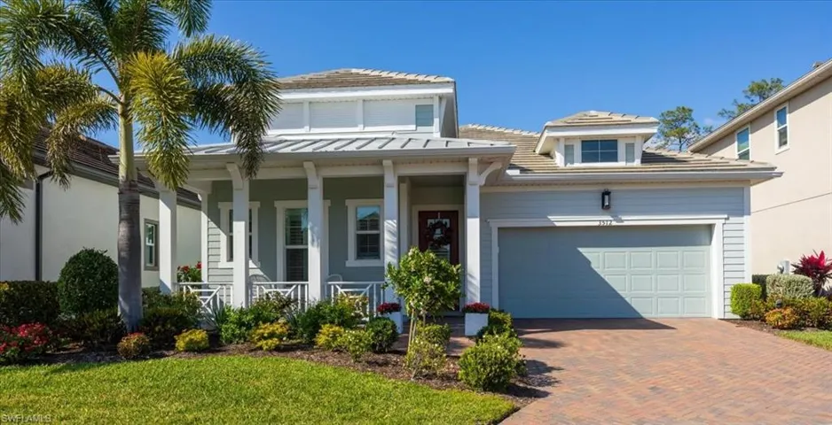 View of front of home with paver driveway, a front porch, and a 2 car attached garage