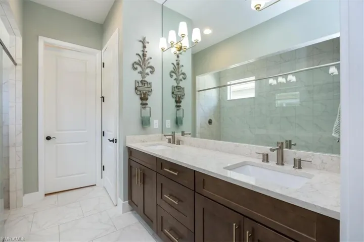 Bathroom featuring a double vanity, a private water closet and tile floors