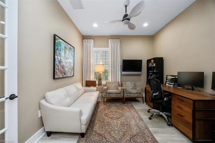 Office featuring recessed lighting, light wood-style flooring, plantation shutters, custom drapery panels and a ceiling fan