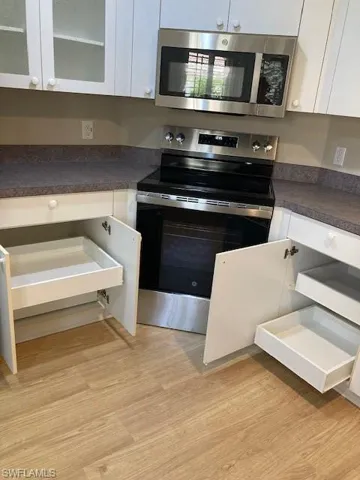 Kitchen features stainless appliances and pull out shelves
