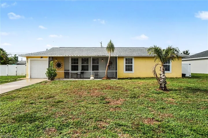 Single-story residence featuring a yellow exterior, white trim, and a gray shingle roof