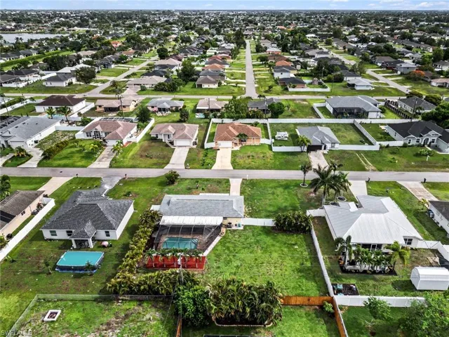Aerial perspective of a residential neighborhood featuring single-story homes with shingle roofs and concrete driveways