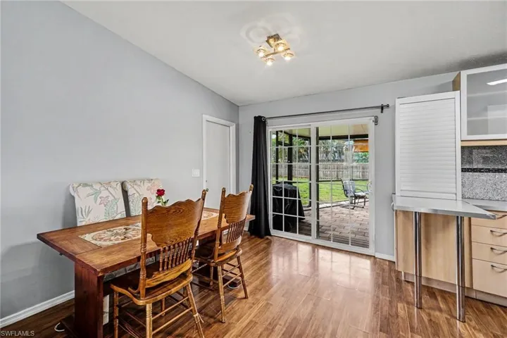 Sliding glass door opens to a paved patio and fenced backyard