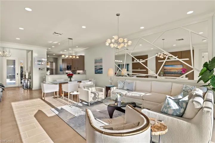 Living area featuring ornamental molding, recessed lighting, visible vents, and an inviting chandelier