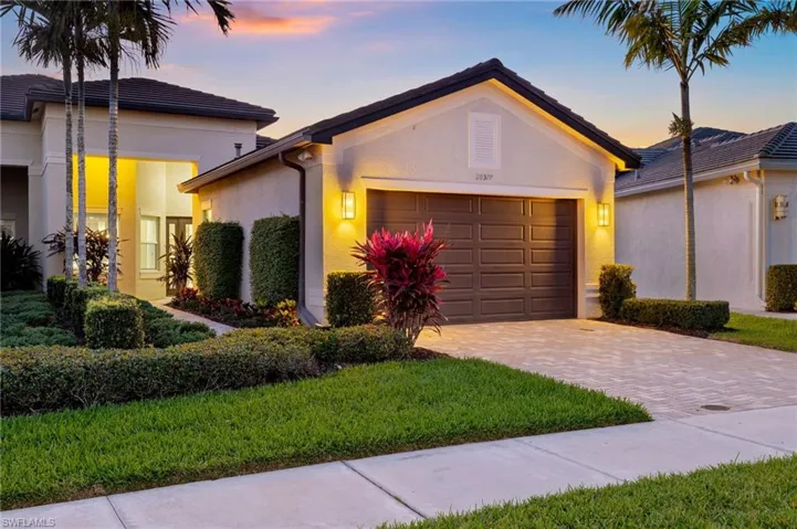 Ranch-style home featuring a garage, a tile roof, decorative driveway, and stucco siding