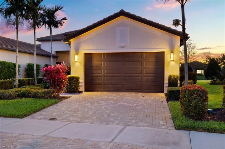 Garage at dusk featuring decorative driveway