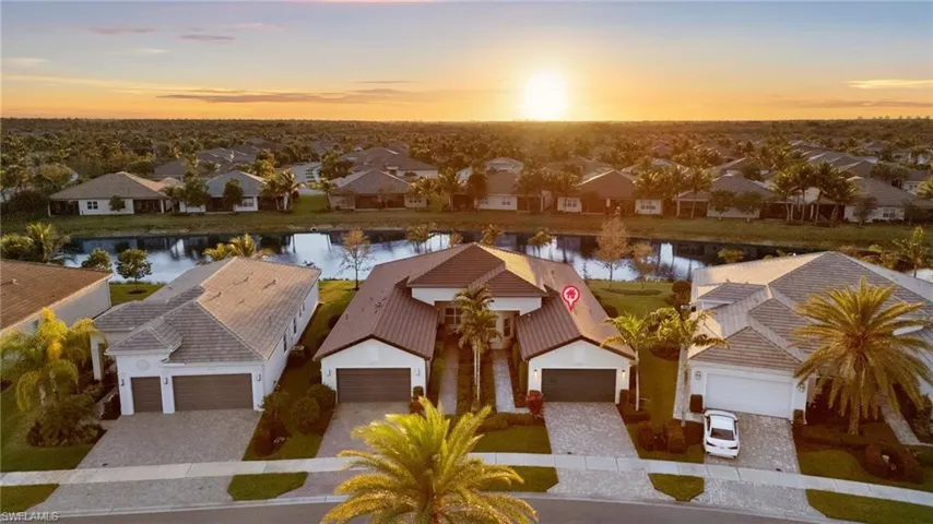 Aerial view at dusk featuring a residential view and a water view