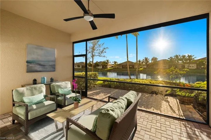 Sunroom with a water view and a ceiling fan