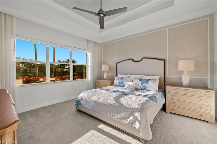 Bedroom with carpet floors, a raised ceiling, ceiling fan, and baseboards