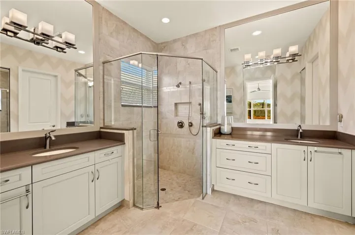 Full bathroom featuring a wealth of natural light, a shower stall, and a sink