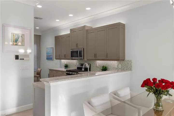 Kitchen with stainless steel appliances, recessed lighting, decorative backsplash, a peninsula, and baseboards