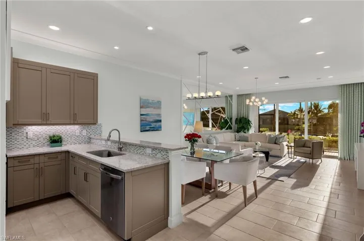 Kitchen with dishwashing machine, a peninsula, a sink, visible vents, and decorative backsplash