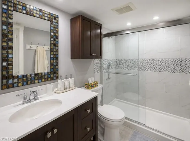 Contemporary bathroom featuring a dark wood-finish vanity with a white countertop and undermount sink