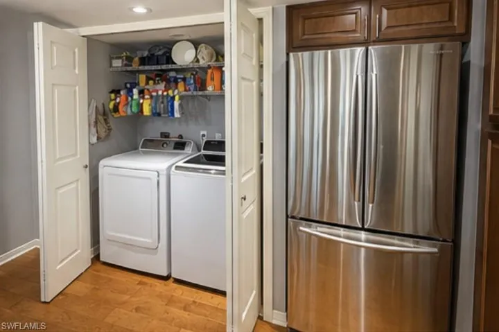 Dedicated laundry closet with white appliances and wire shelving