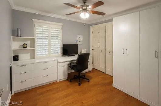 Light-filled interior featuring wood-finish flooring and a ceiling fan