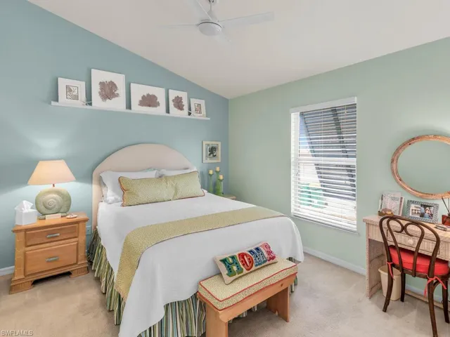 Carpeted bedroom featuring vaulted ceiling and ceiling fan