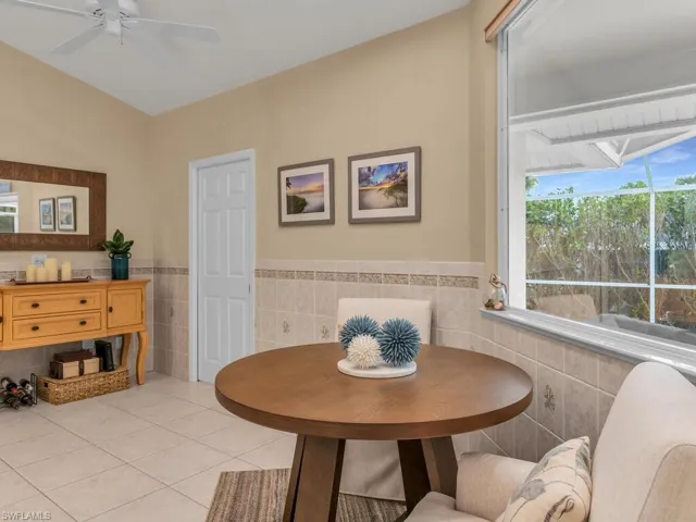 Tiled dining space featuring tile walls and ceiling fan