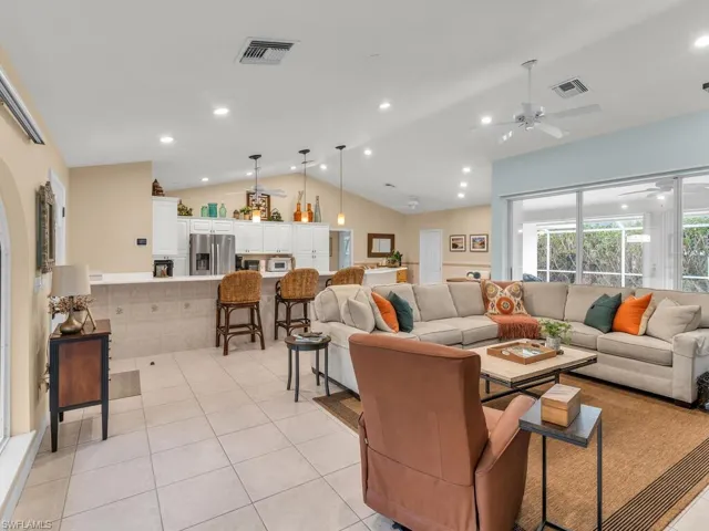 Tiled living room featuring lofted ceiling and ceiling fan
